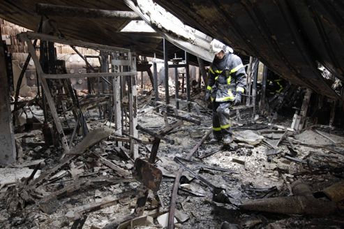 French firemen inspect damage inside a leisure centre after overnight clashes where gangs of youths set cars, bins and a school ablaze in Amiens